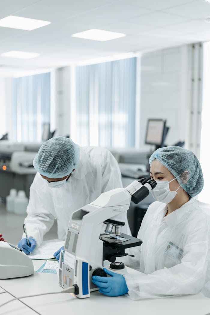 Scientists working with a microscope in a high-tech laboratory setting, focusing on research.